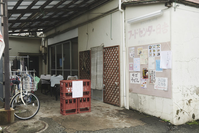 店舗入り口前に積まれている、ビール運搬用の赤いコンテナ。